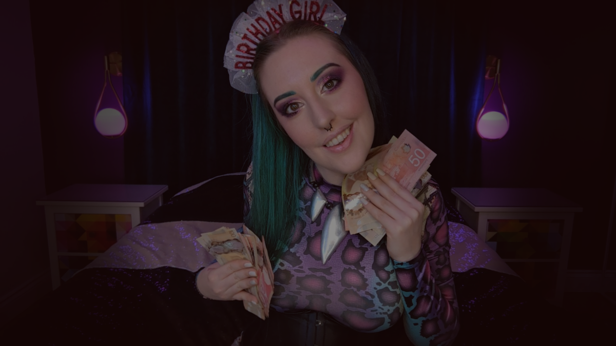 Goth Alt Girl Femdom Goddess Miss Faith Rae smiles at you through the camera as she poses on her bed with a bunch of $50 and $100 bills. Her long, straightened hair is half black, half turquoise, and her eyebrows are styled to match. Findom Demoness Faith Rae's eyeshadow is purple and gold with glitter, and her lips are a soft, natural pink. Her hazel eyes stare straight into your soul as she presses handfuls of cash to her body. The curve of Daddy Faith Rae's perfect perky tits is visible through her rainbow snakeskin patterned bodysuit, and her black underbust corset accentuates her waist. Alternative Dominant Woman Miss Faith Rae wears a frilly pink headband with the words, Birthday Girl on it. Miss Faith Rae is a multifaceted Domme who is prepared to take everything you have to give, and more.